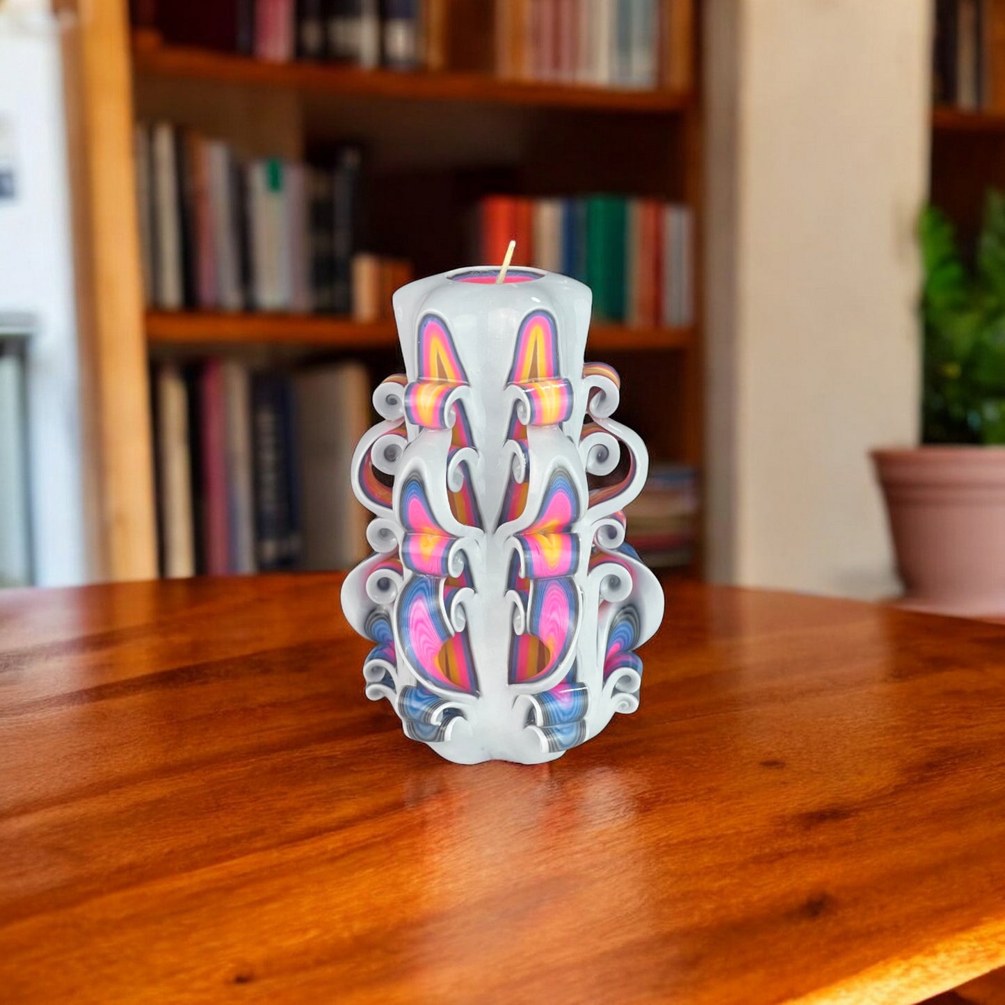 A multicolored candle with a geometric pattern, predominantly white with blue and pink accents, and a visible wick.
Used for romantic dinner, wedding, proposal, baptazing event.